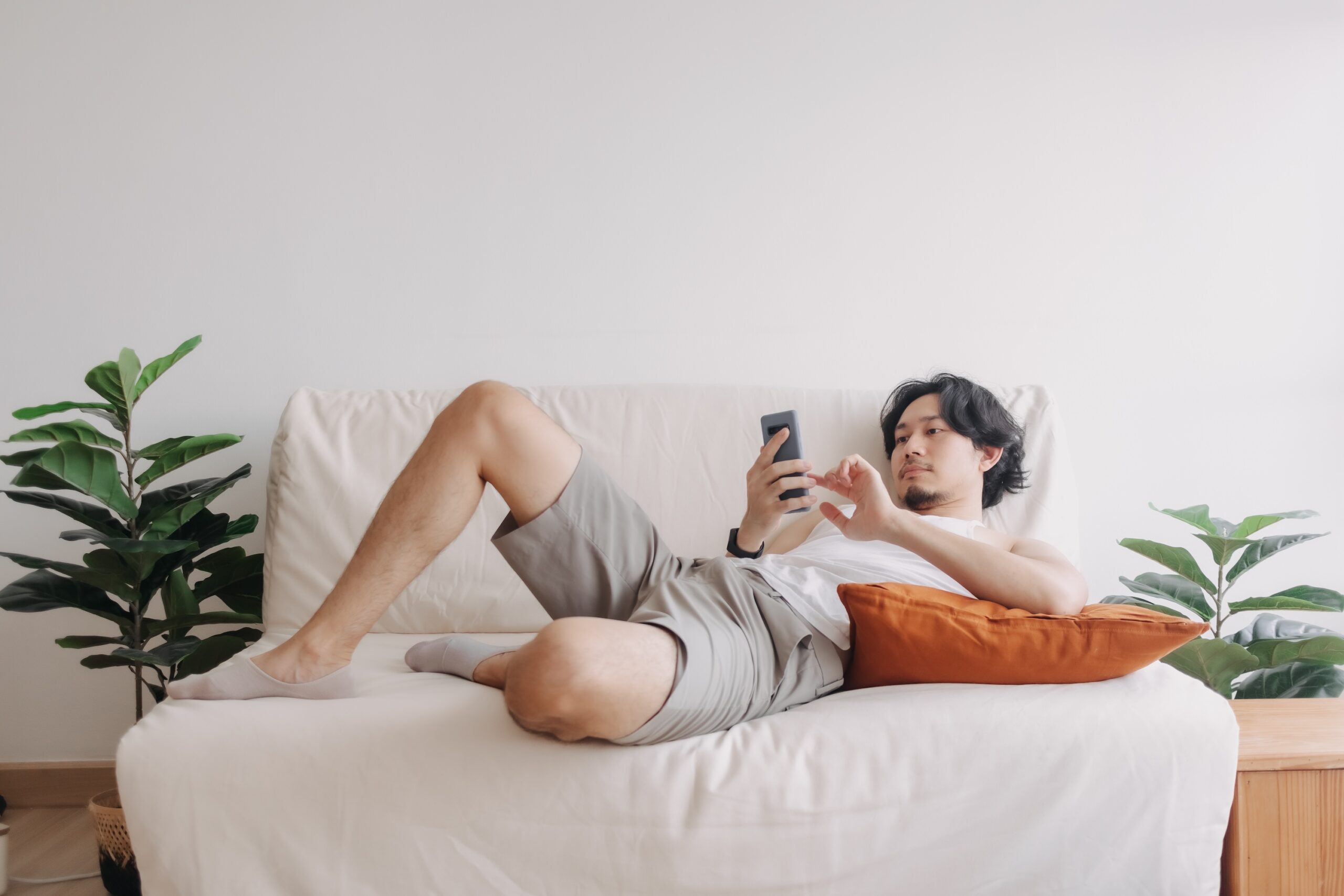 A young man relaxes on a couch.