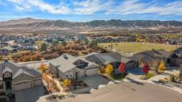 The photo shows real estate drone photography of a beautiful neighborhood with mountains behind it. Shot by a photographer from Next Door Photos.