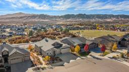 The photo shows real estate drone photography of a beautiful neighborhood with mountains behind it. Shot by a photographer from Next Door Photos.
