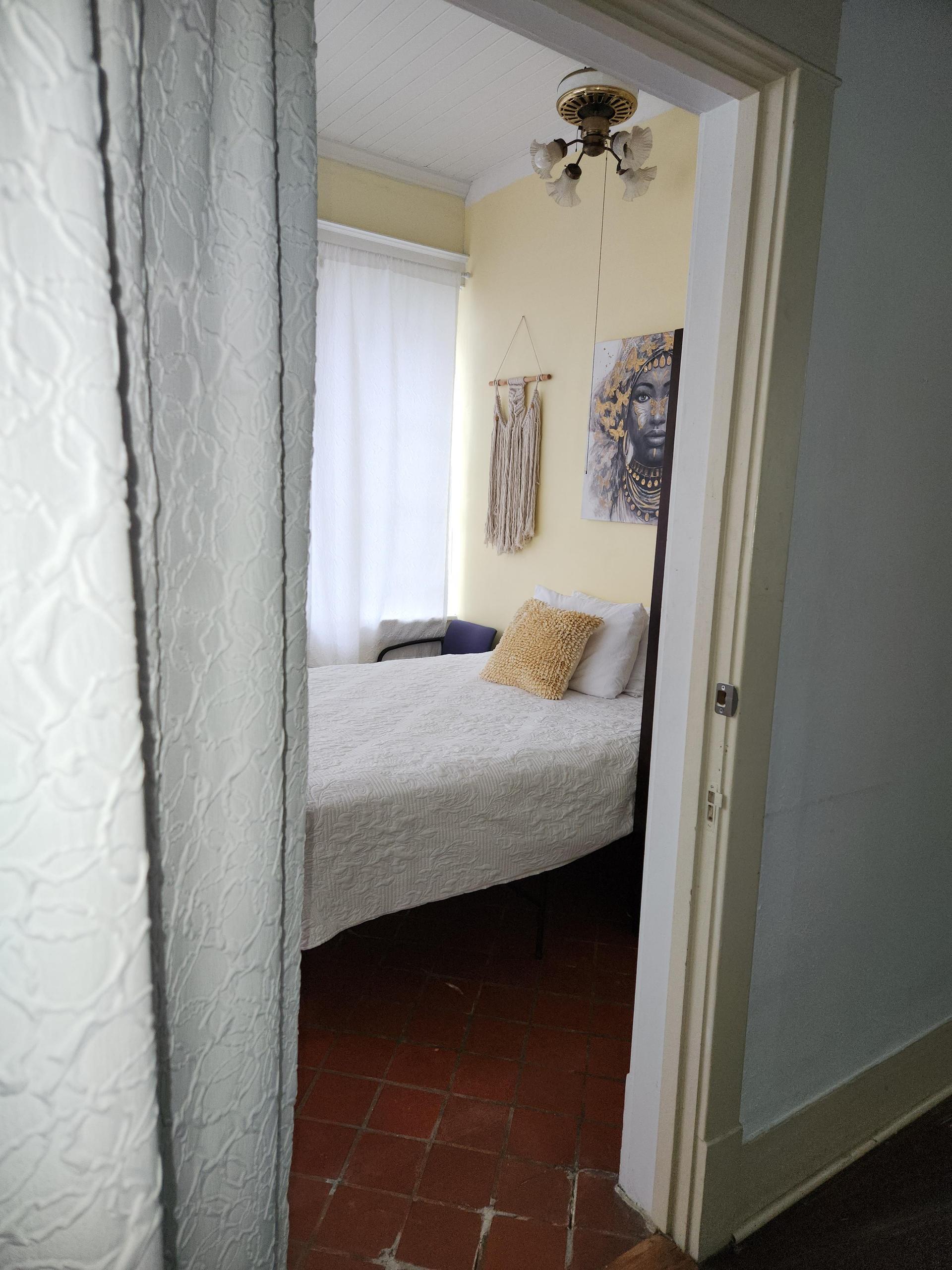 Noire room. A bright courtyard view with 5 windows. Queen bed, tile floor, window AC/Heat unit, dedicated work station and TV