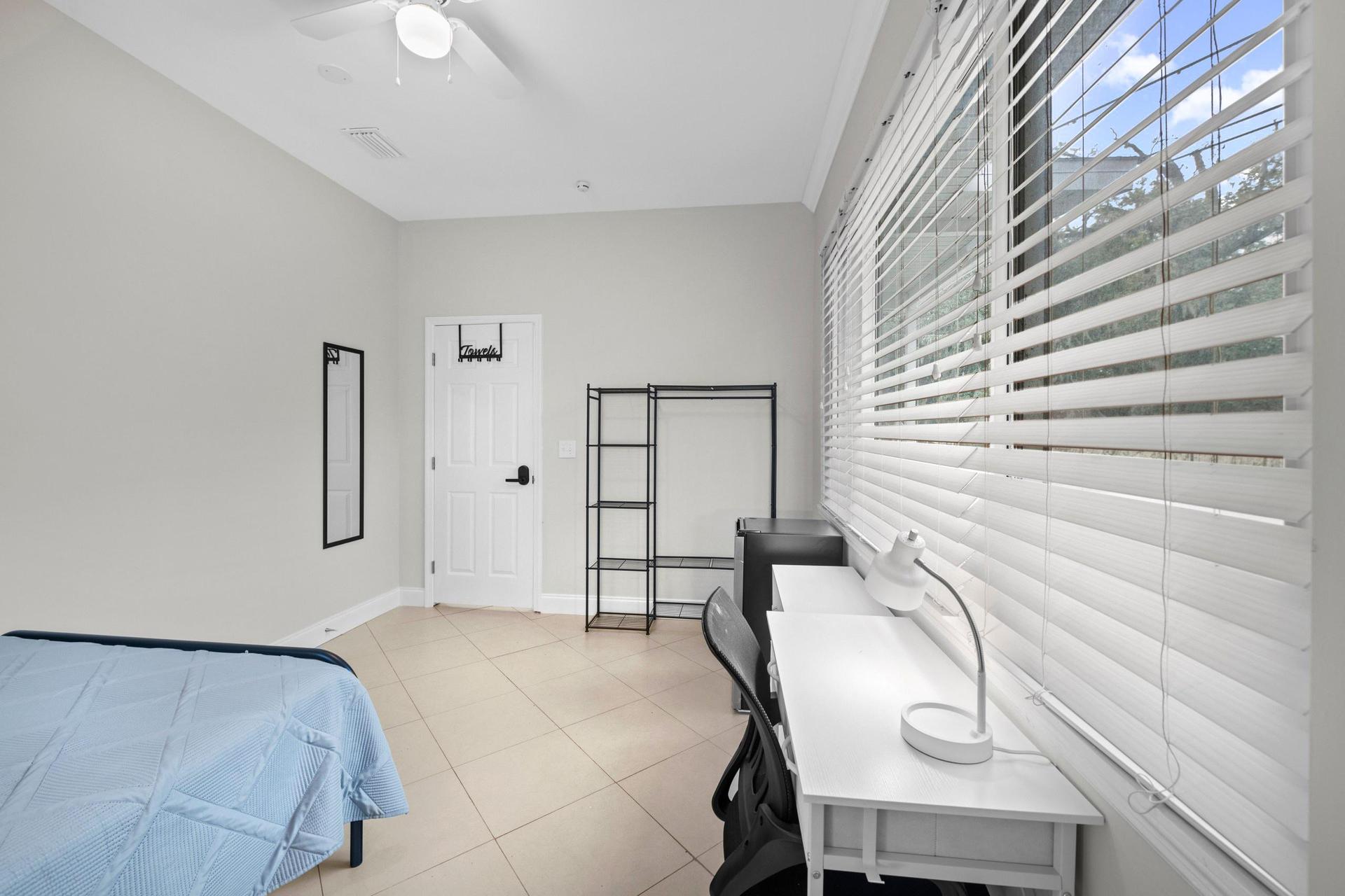 Desk with lamp & office chair.  Clothing rack, towel bar & mirror, plus ceiling fan