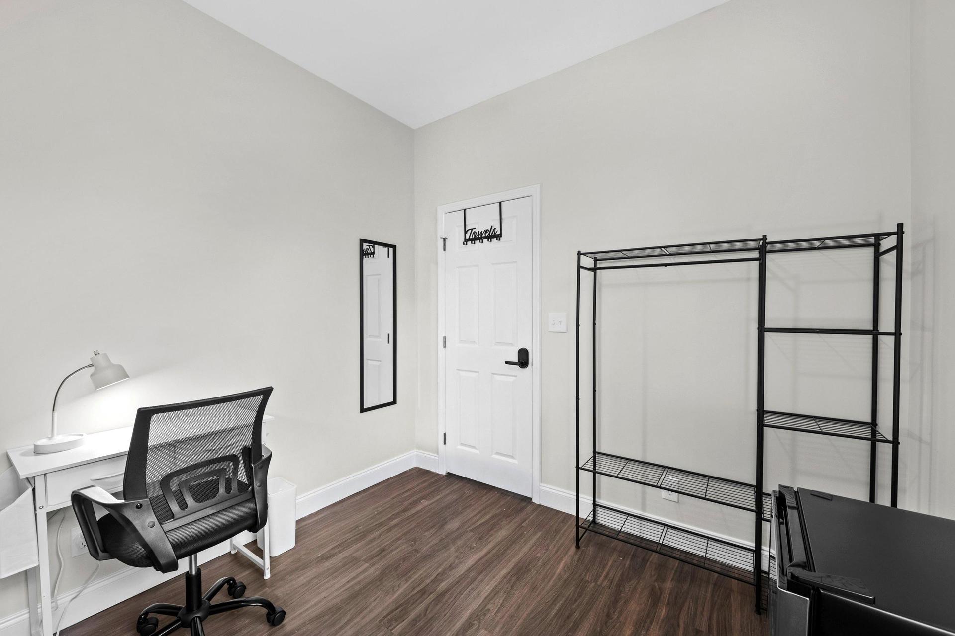 Desk with lamp & office chair.  Clothing rack, towel bar & mirror, plus ceiling fan