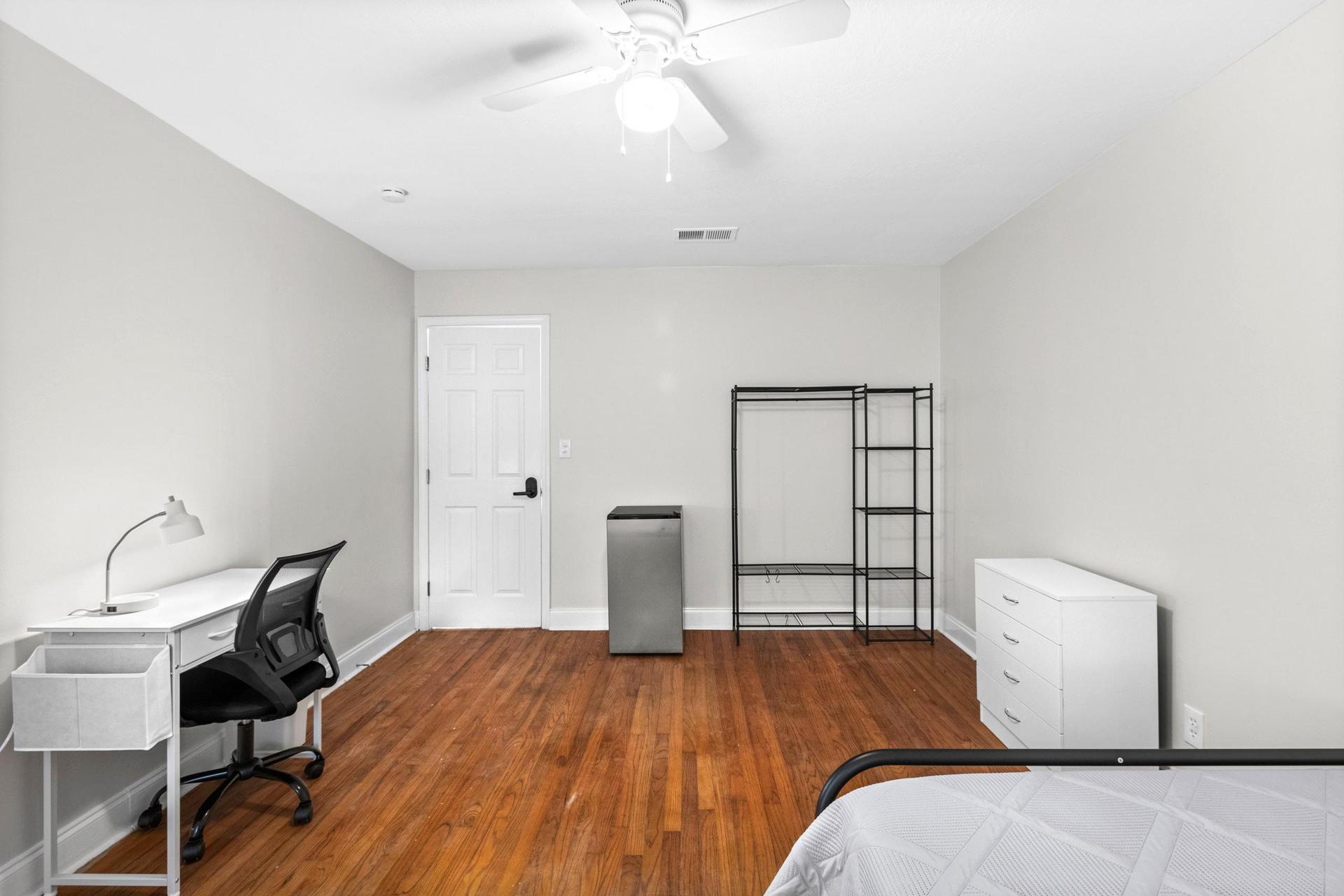 Desk with lamp & office chair.  Clothing rack, towel bar, mirror & dresser, plus ceiling fan