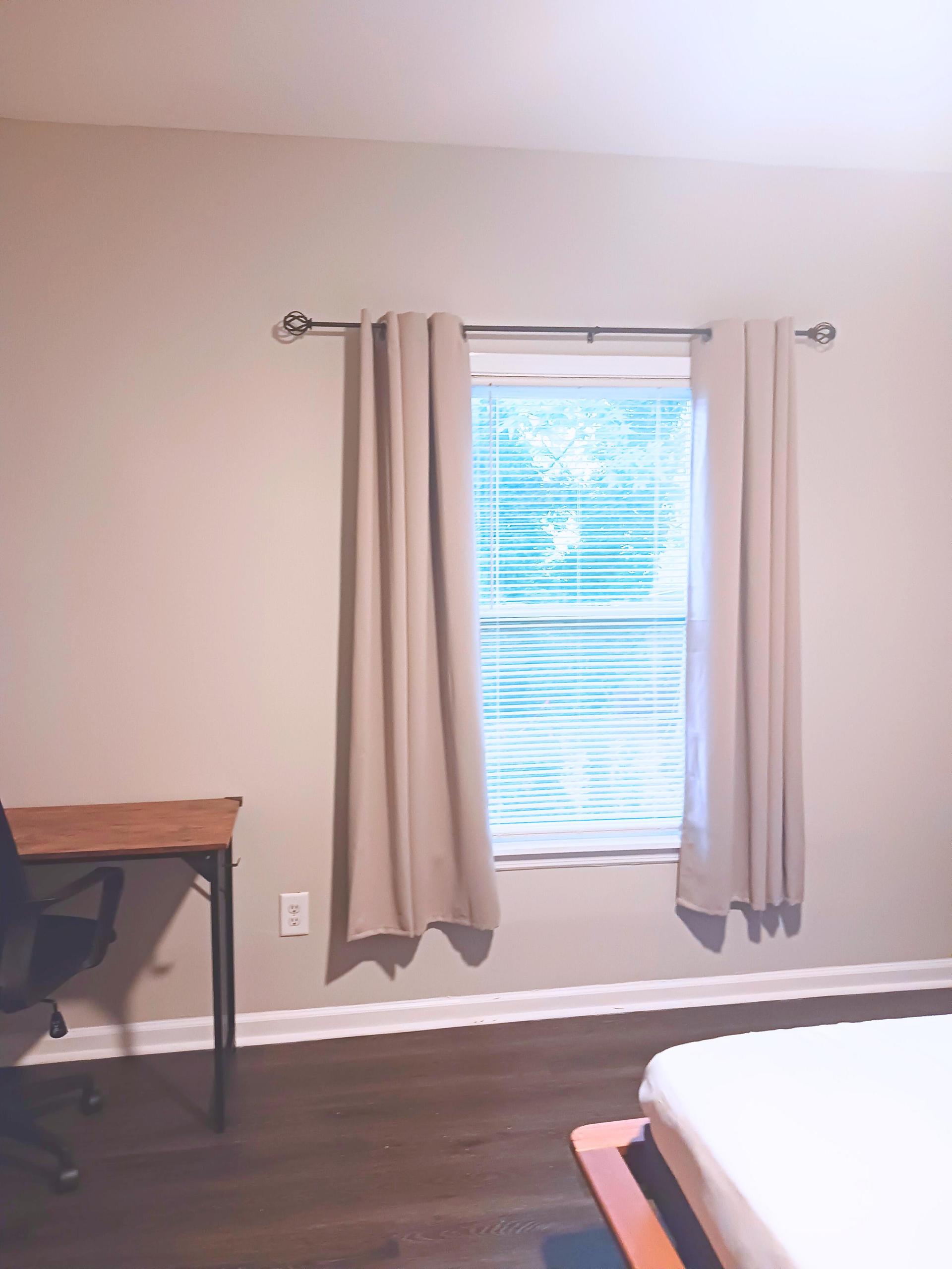 Window provides natural lighting. Curtains m