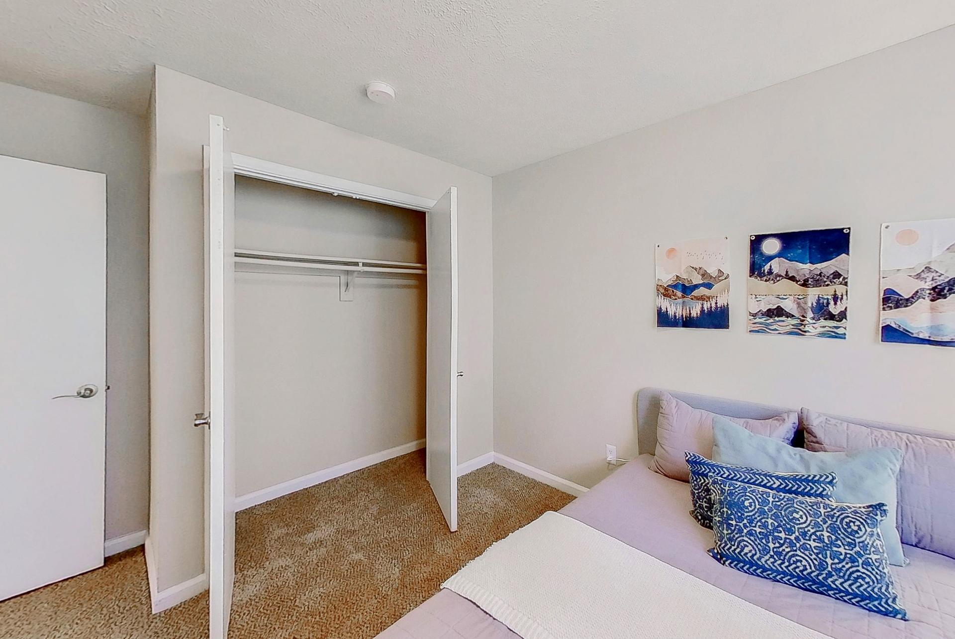 Lovely room equipped with a queen bed, night stand, vintage lamp, dresser and a reach-in closet.