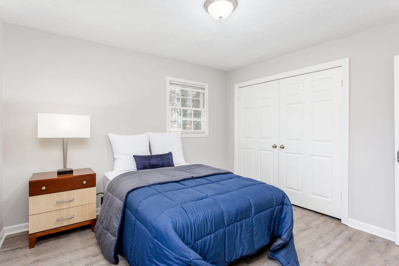 Master bedroom with large closet, nightstand and lamp.