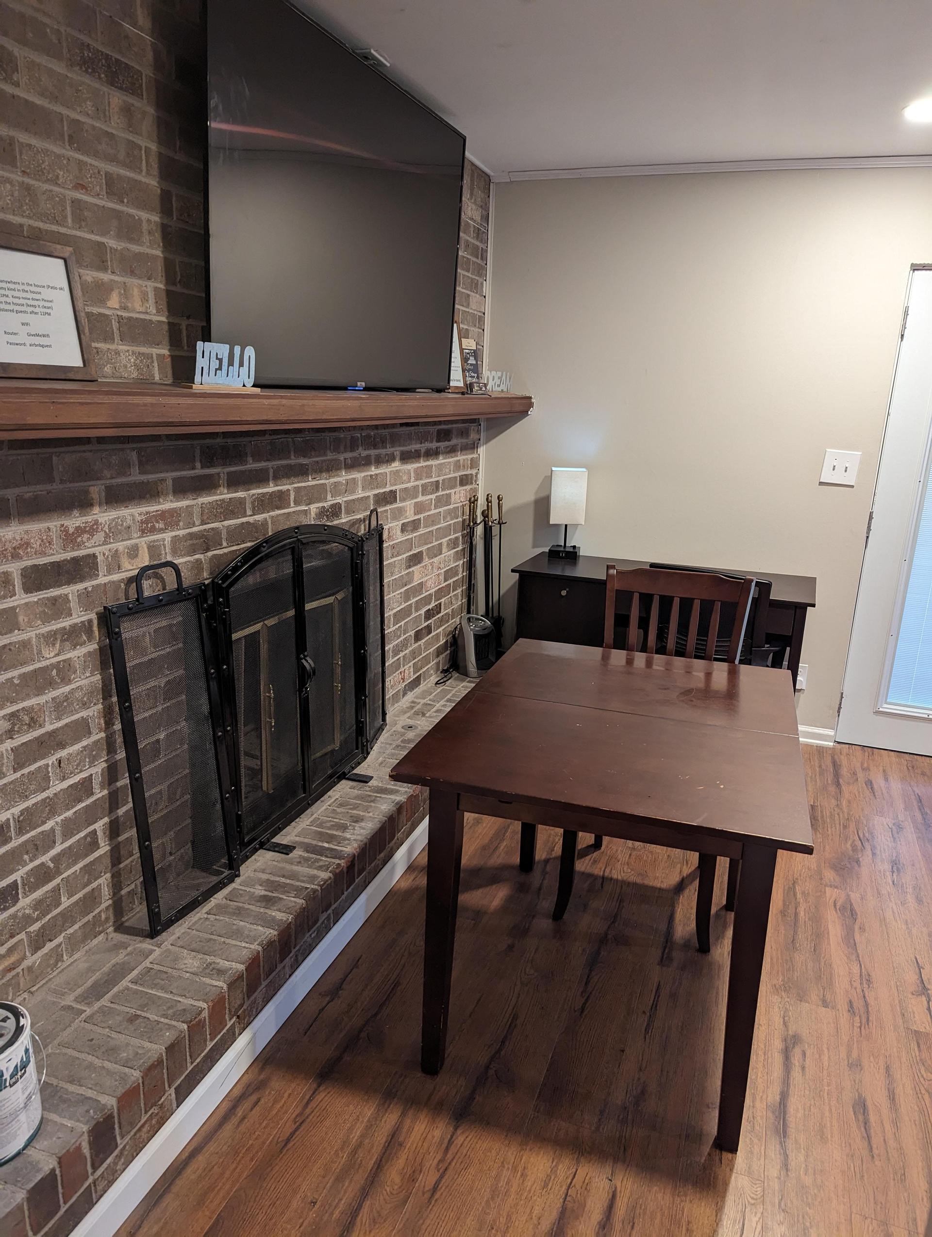 fireplace (not working) with TV on mantle and small dining table