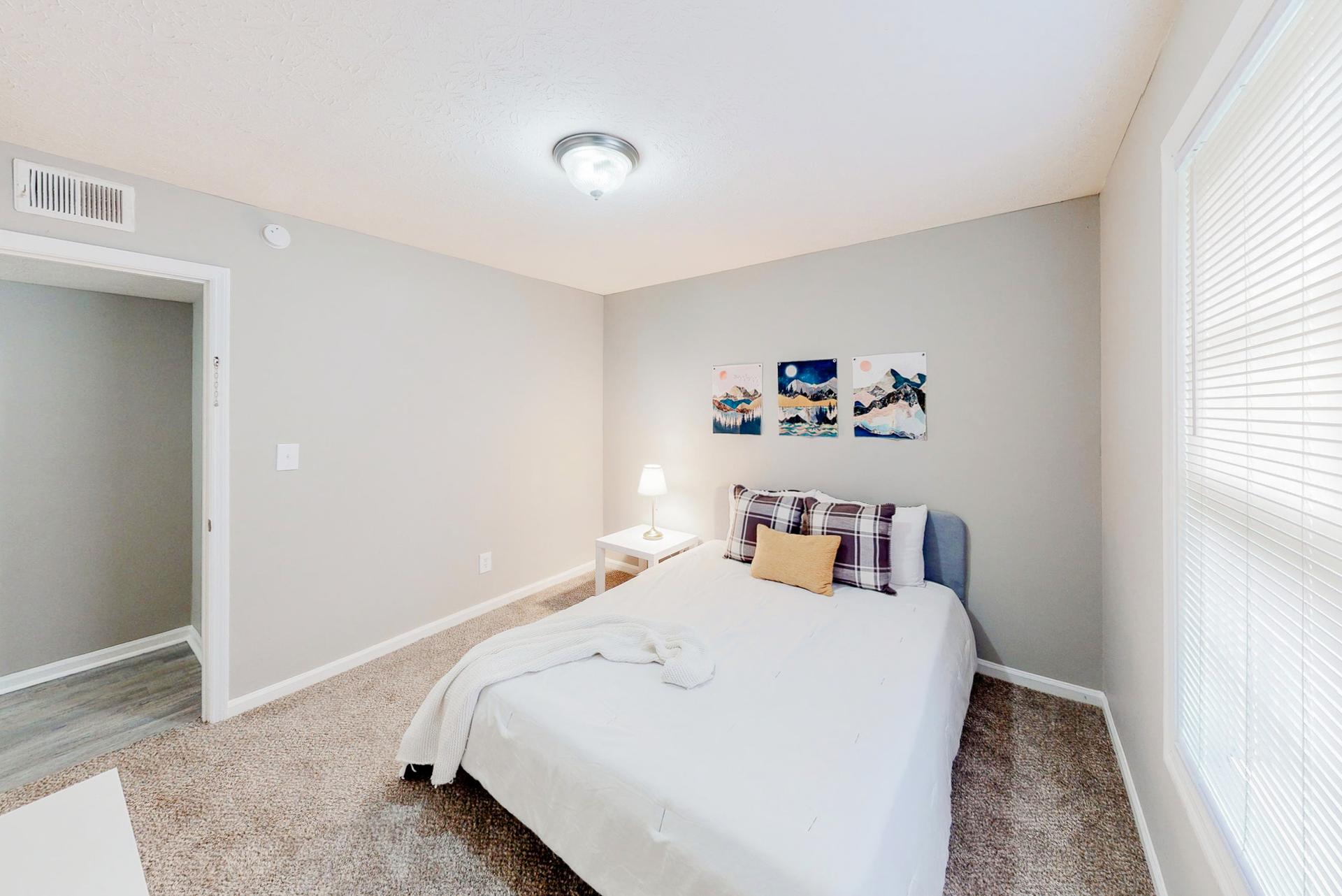 Spacious bedroom featuring a queen bed, nightstand, dresser and reach-in closet.