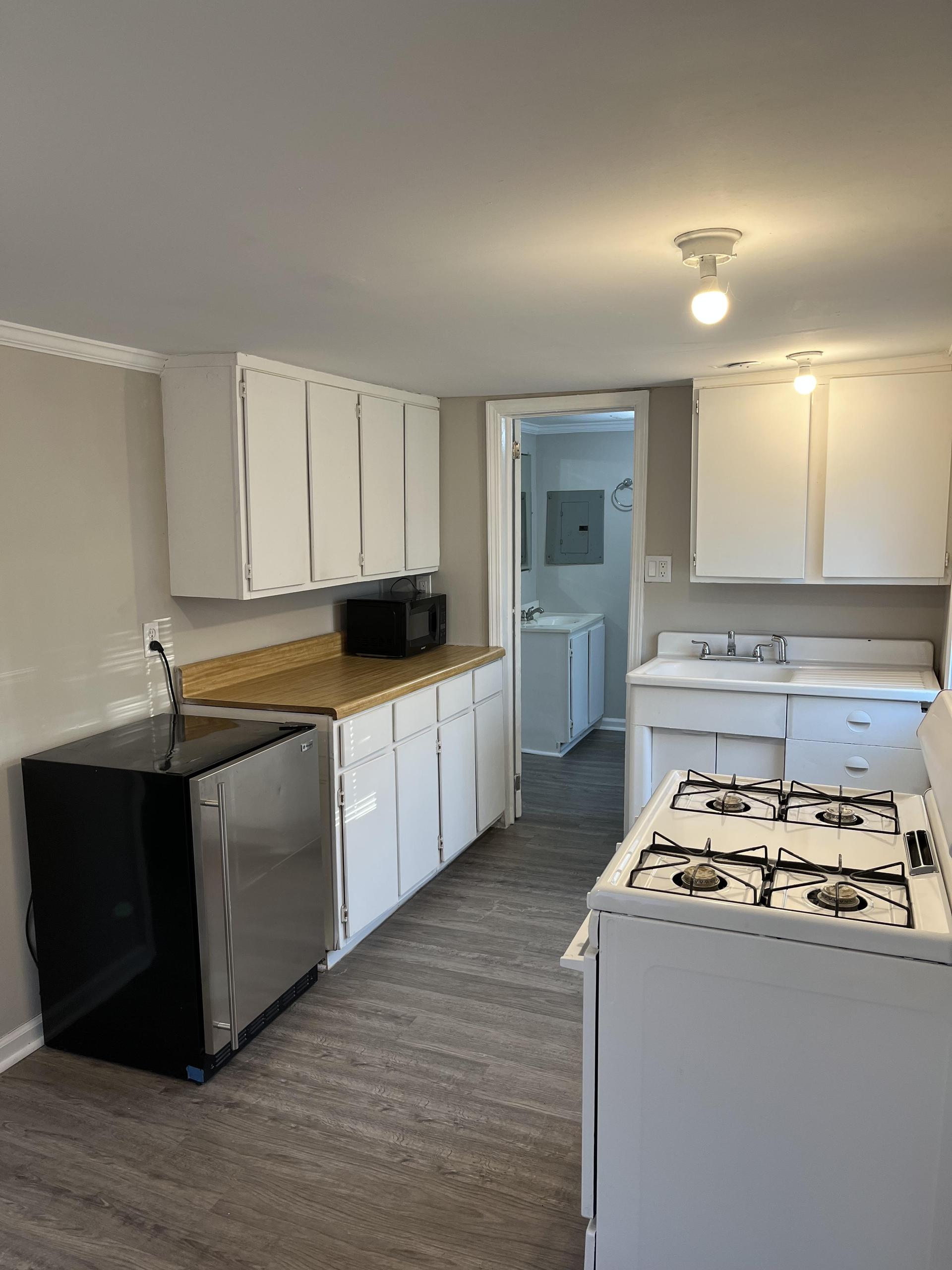 This room is a full apartment with a kitchen, sink, microwave, stove, and mini fridge.