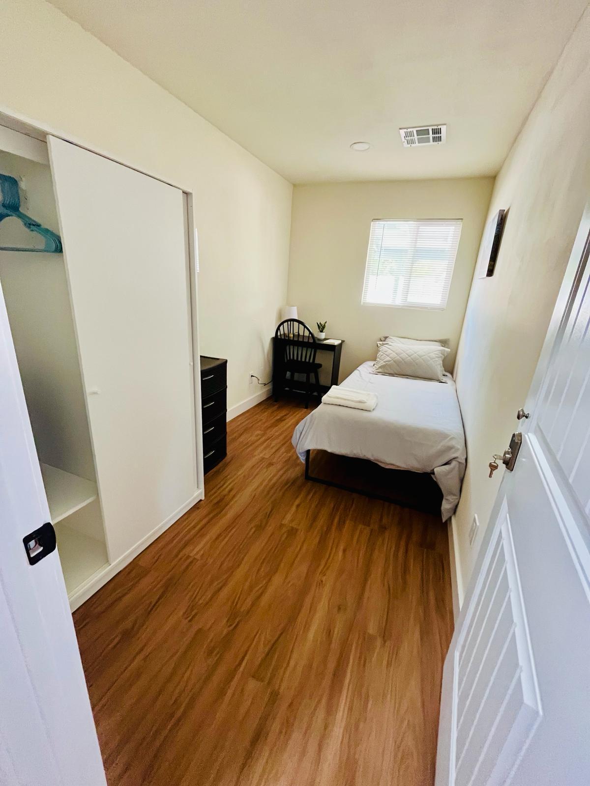 twin bed, work space, drawers and small closet