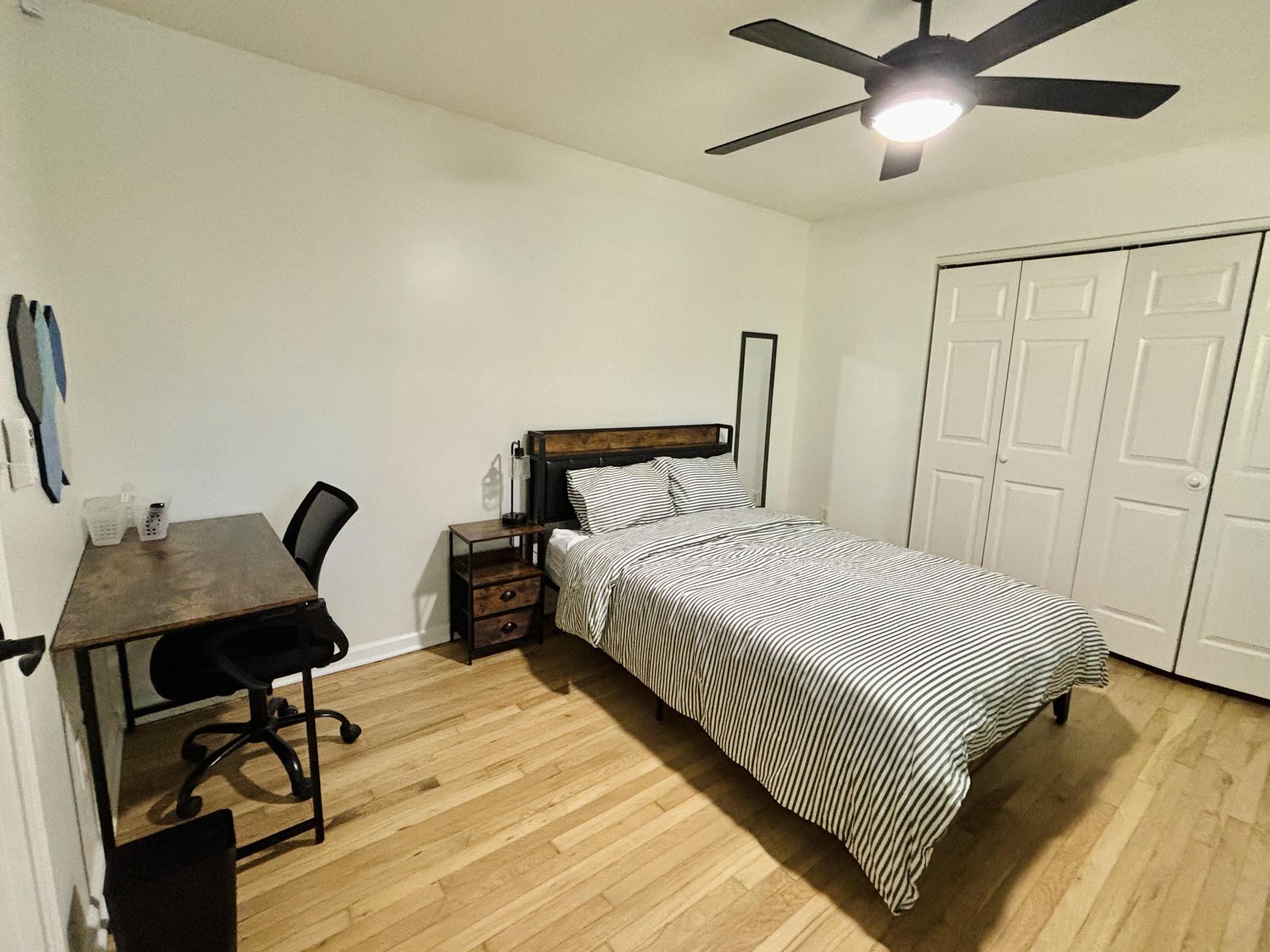 Spacious bedroom with full sized bed, all linens included, mounted smart TV, desk, bulletin board, and full length mirror!