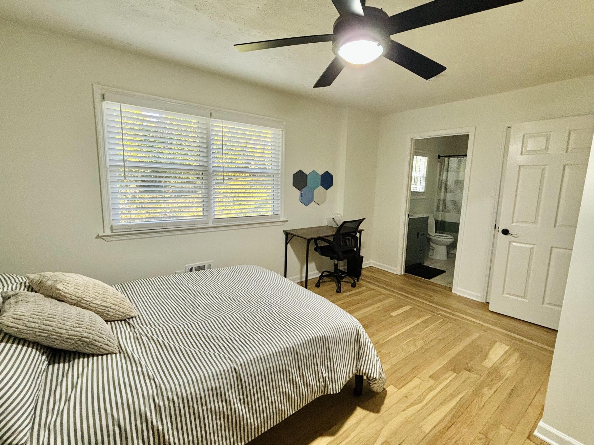 Spacious bedroom with full sized bed, all linens included, mounted smart TV, desk, bulletin board, and full length mirror!