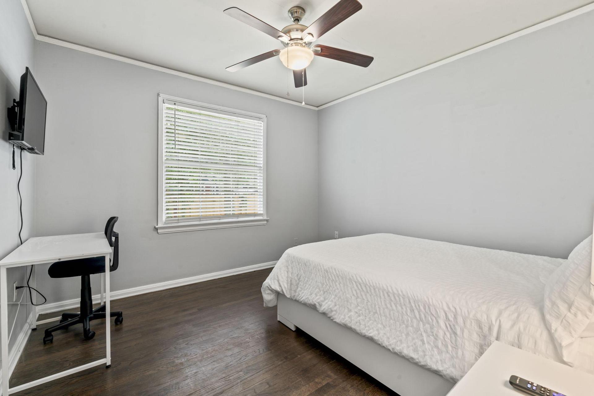 This room includes TV, workspace and ceiling fan