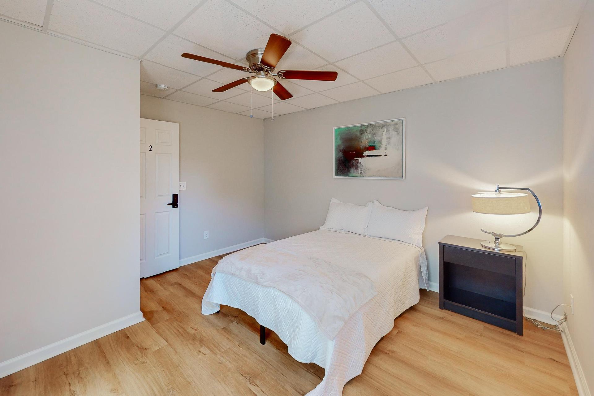 Bedroom complete with full size bed, nightstand, desk, ceiling fan and closet.