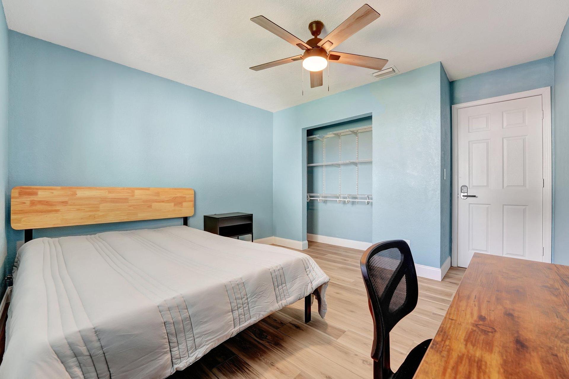 Bedroom with desk, tv and closet