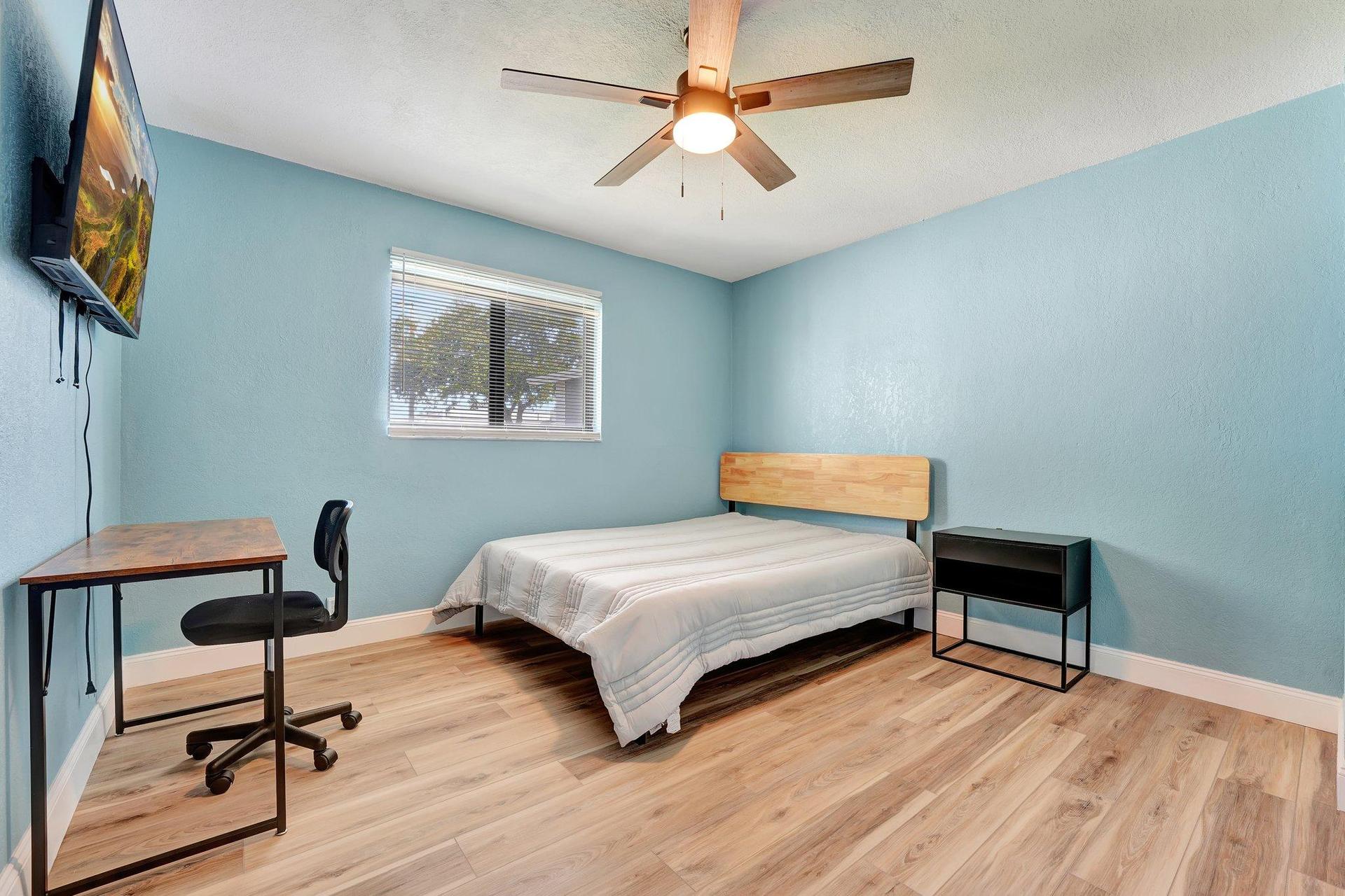 Bedroom with desk, tv and closet