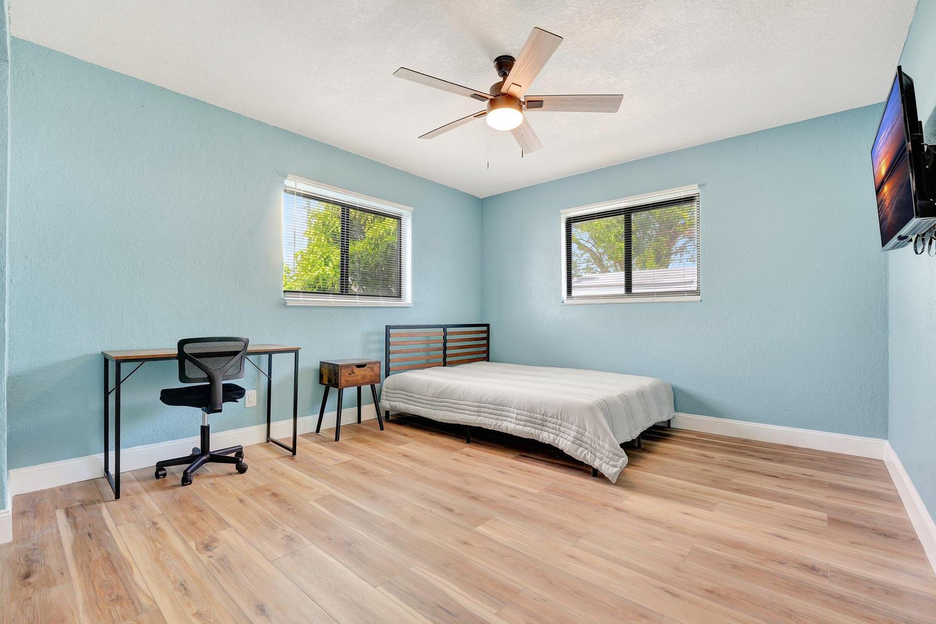 Large bedroom with tv and desk.