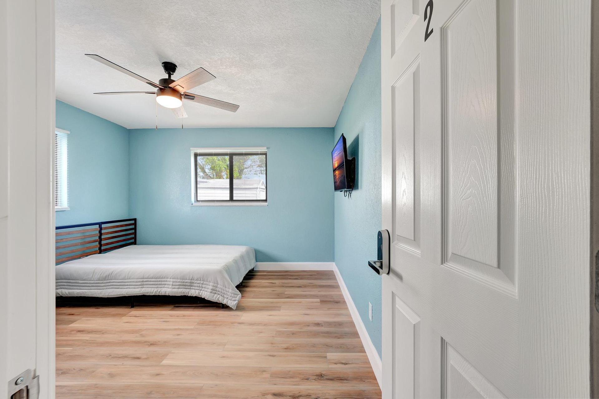 Large bedroom with tv and desk.