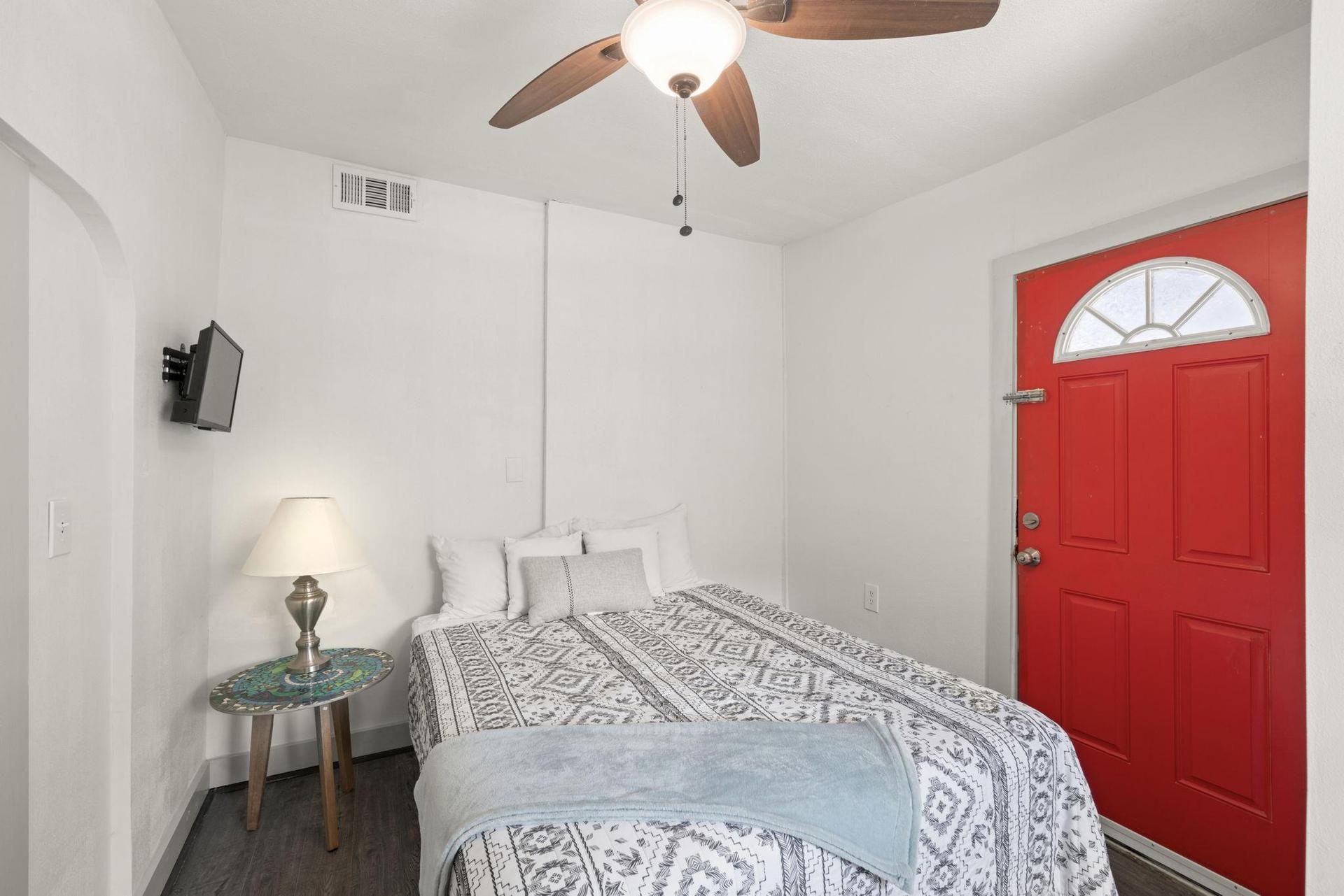 This bedroom has a red exterior door.