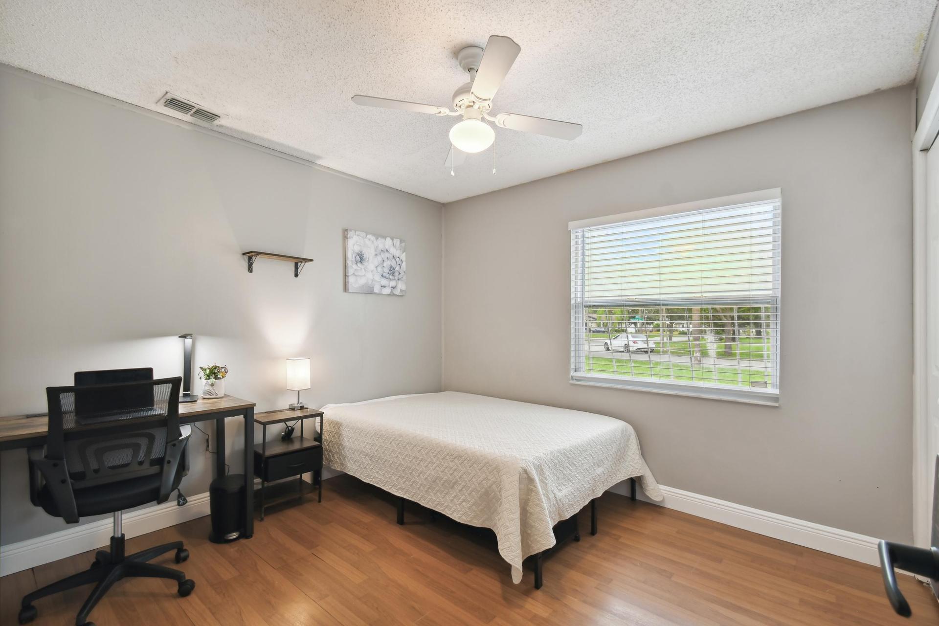 Full size cozy bed, with end table, light and storage container under the bed.