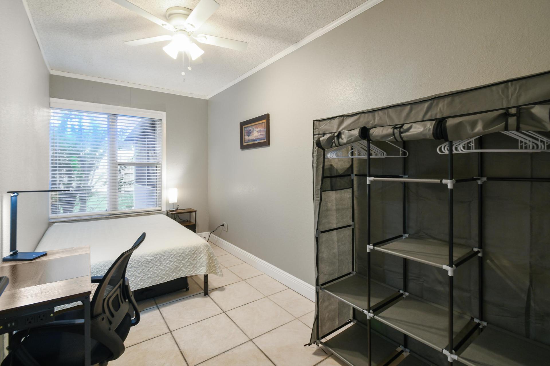 Full size cozy bed, with end table, light and storage container under the bed.