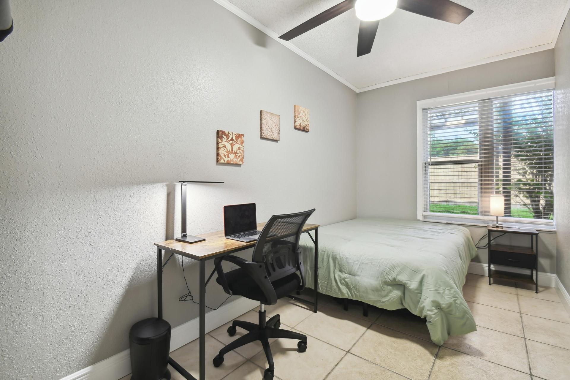 Full size cozy bed, with end table, light and storage container under the bed.