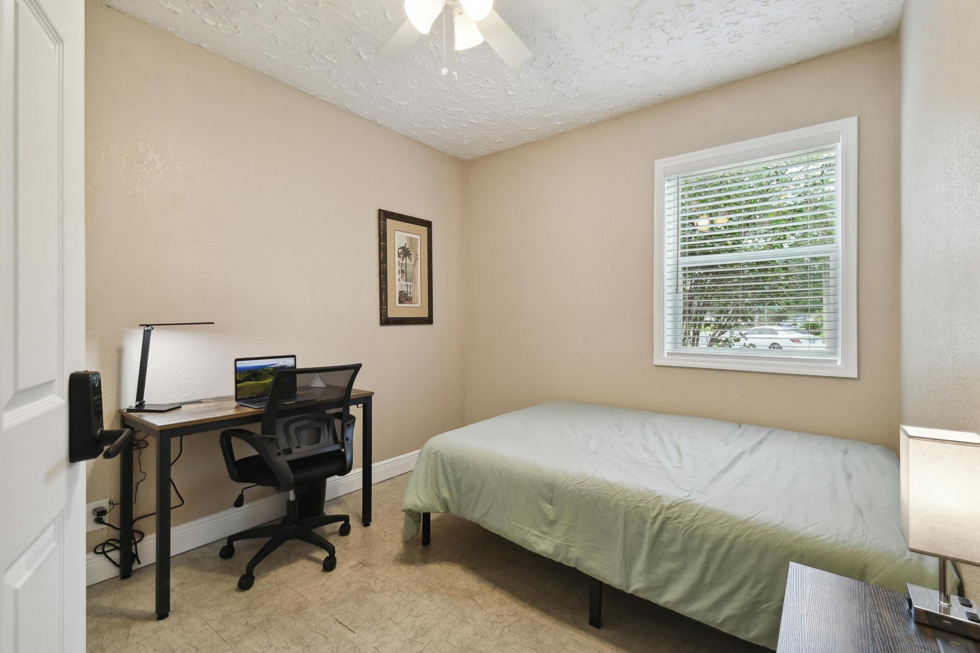 Full size cozy bed, with end table, light and storage container under the bed.