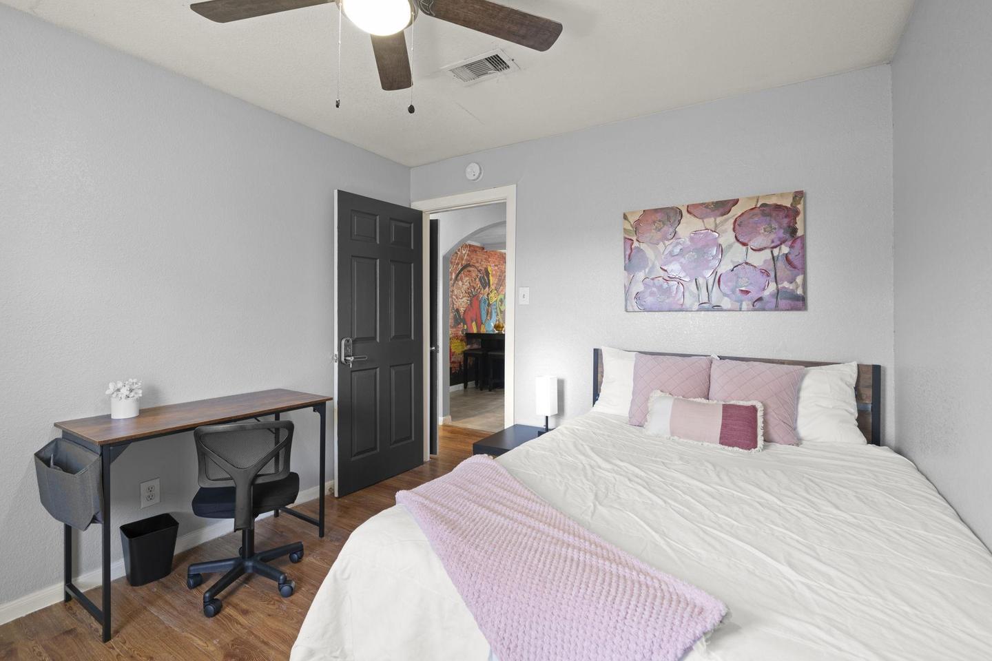 Hallway room near bathroom includes ceiling fan and smart TV