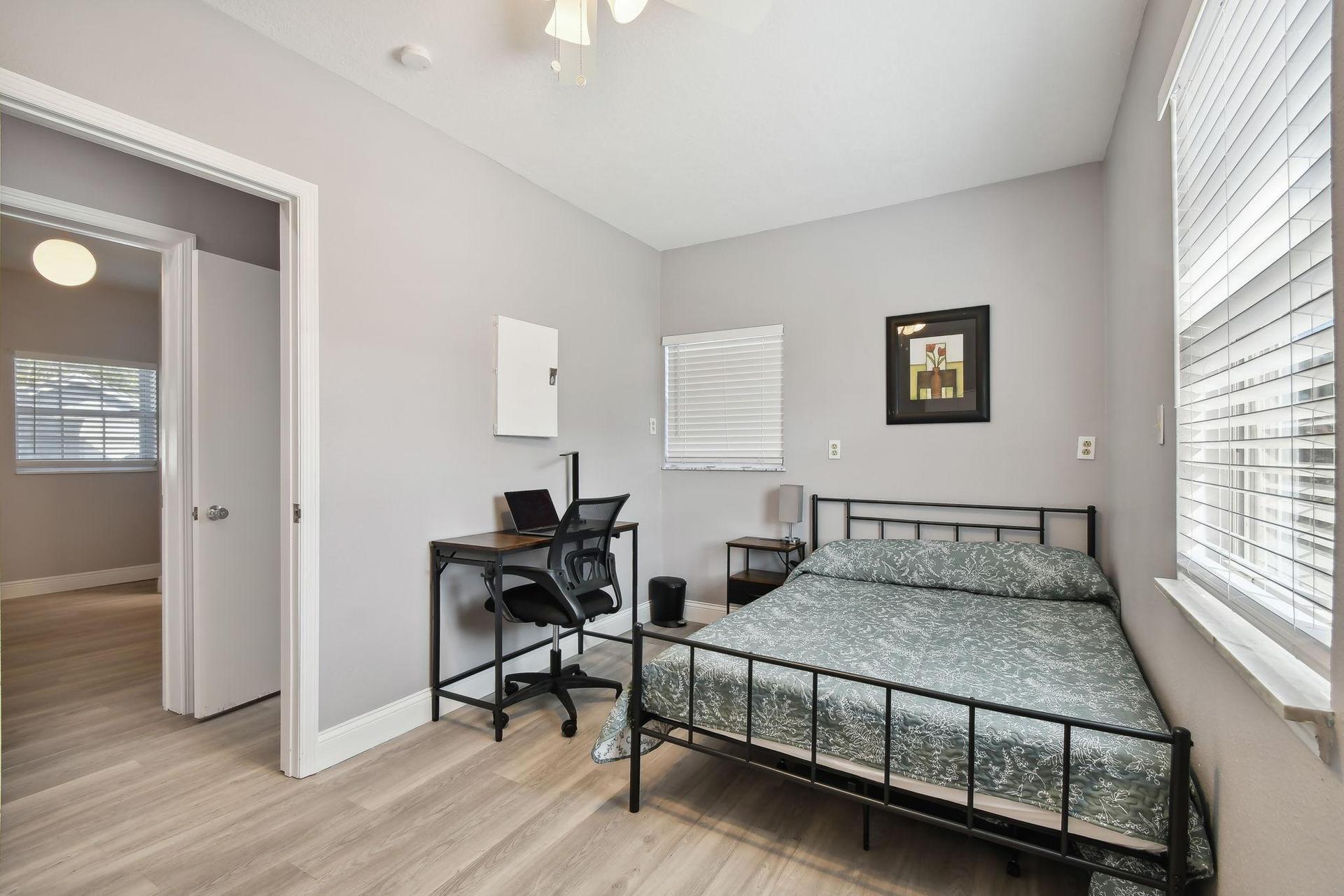 Full size cozy bed, with end table, light and storage container under the bed.  Desk, chair & light.  Next to bathroom.